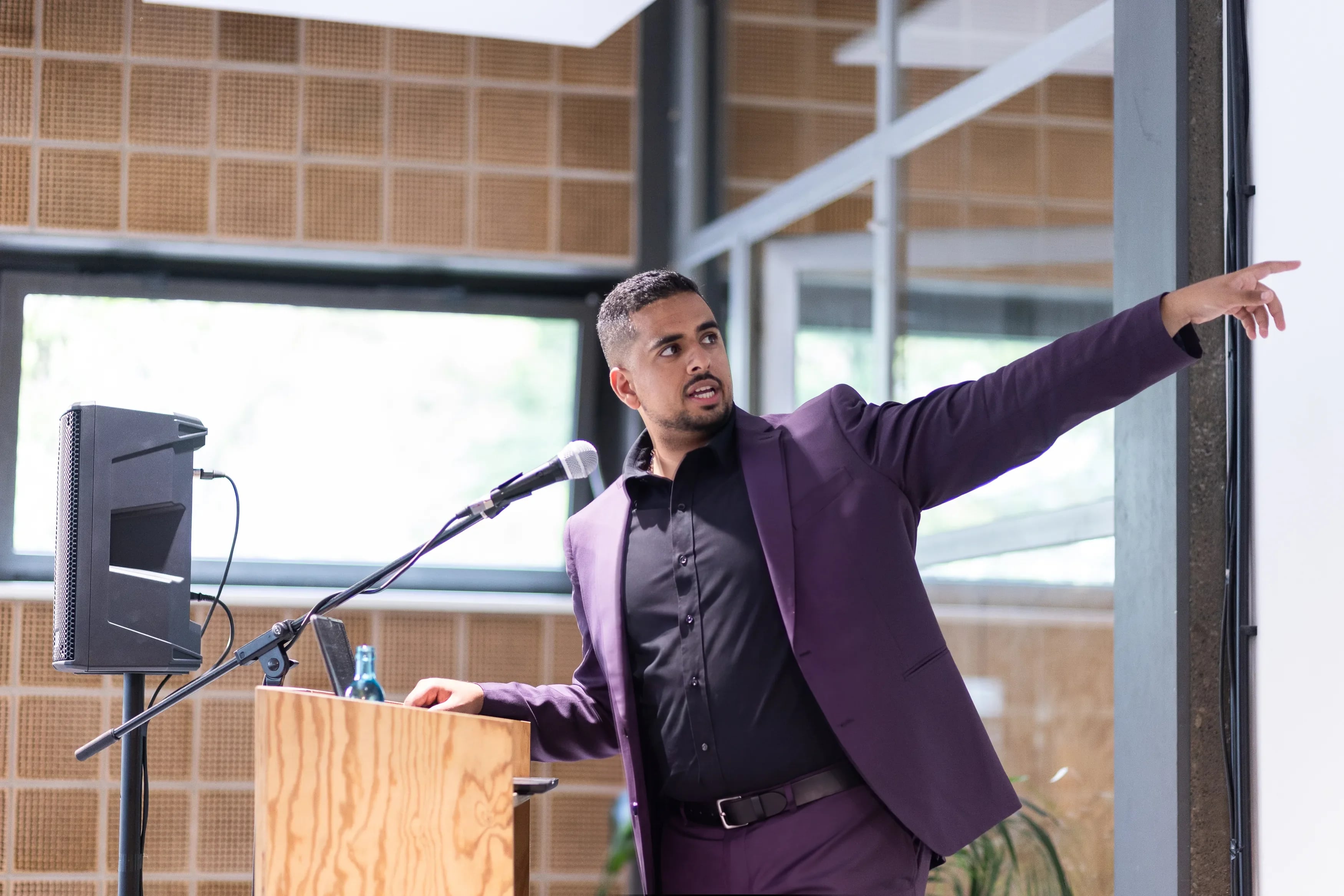 Mark commanding the stage against industrial windows
