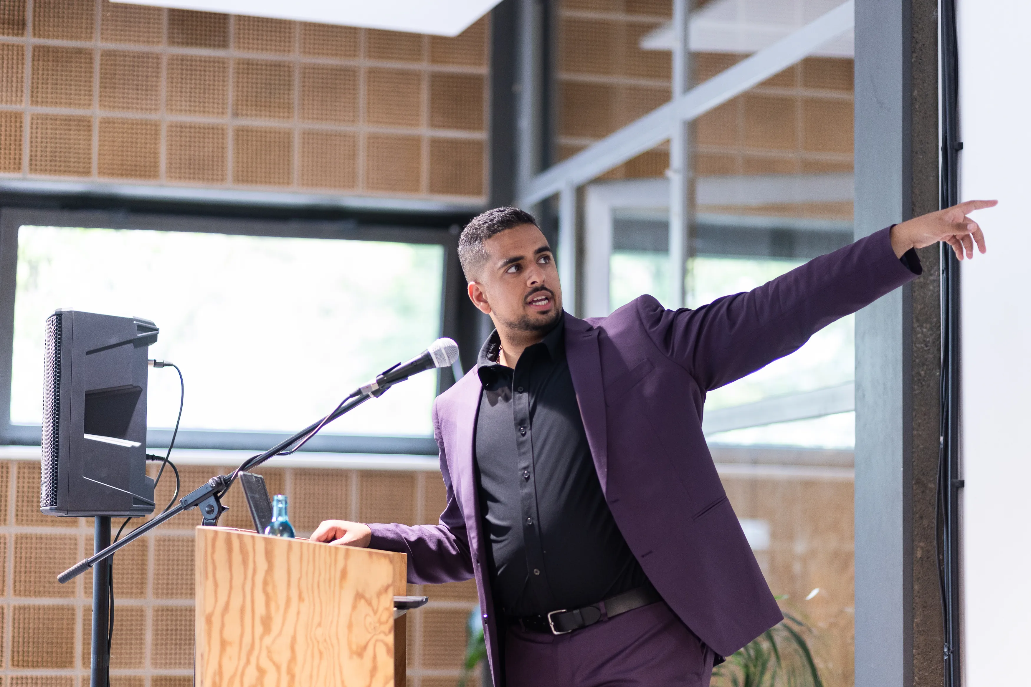 Mark commanding the stage against industrial windows